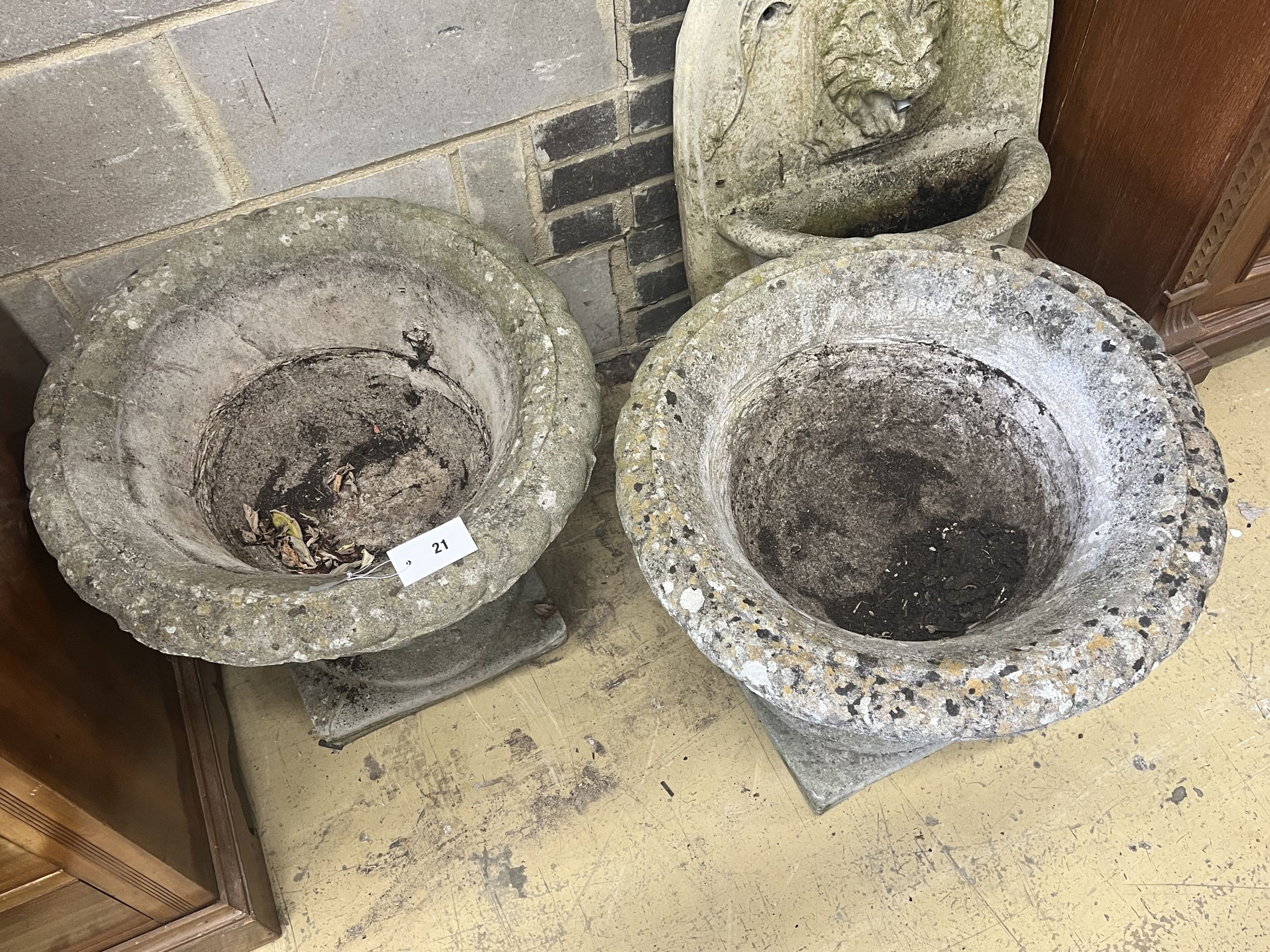 A pair of reconstituted stone circular campana garden urns, diameter 54cm height 48cm